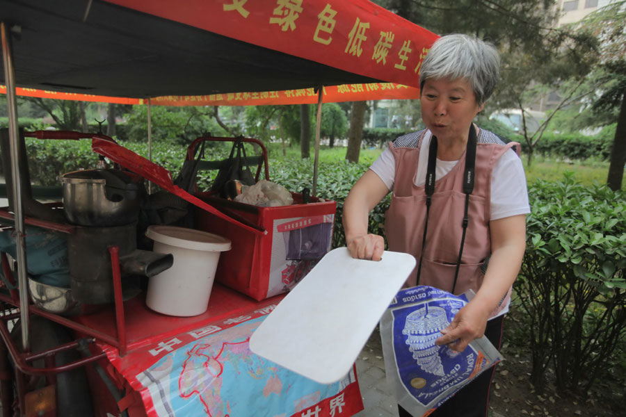 The couple wears essential sport clothes while packing items like sleeping bags and food in their pedicab.[Photo/China Daily]