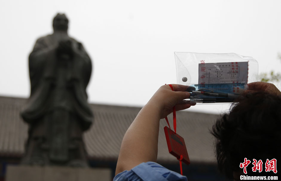 A student’s mother prays in front of the Statue of Confucius with student’s admission sheet of exam in her hand in Confucian temple in Beijing as national college entrance exam (Gaokao) is around the corner. Every year before Gaokao, loads of students accompanied by their parents come and pray at Confucian temple. (CNS/Liu Guanguan)