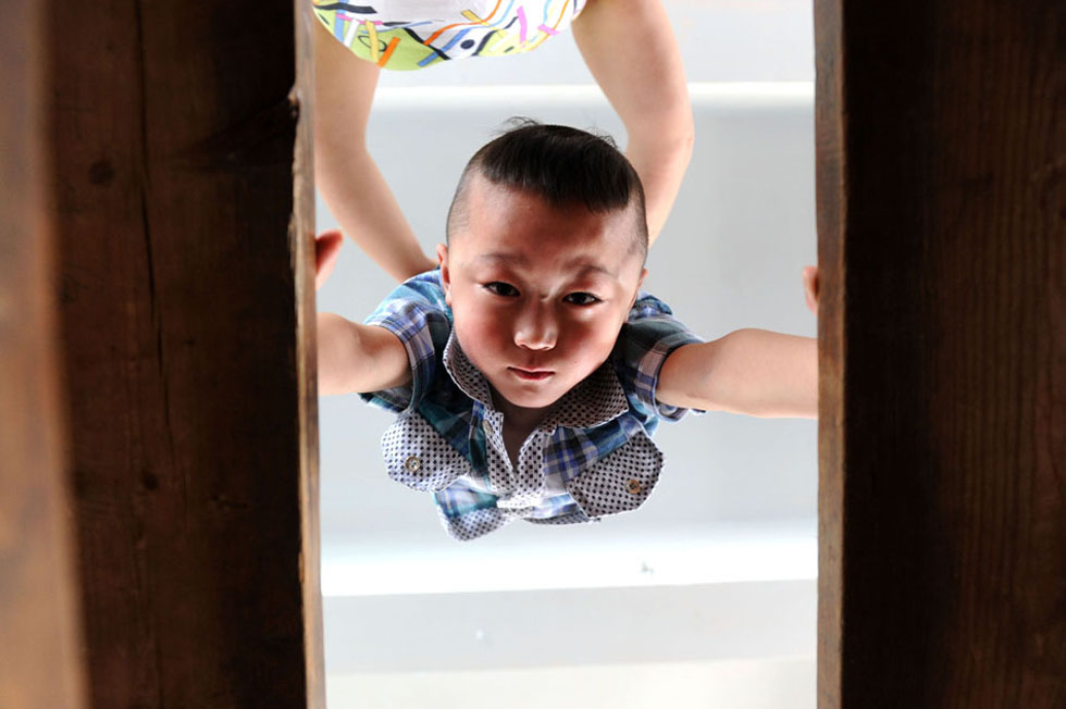 Qin Shaojie, 6, practices handstand, May 28, 2013, in Linquan county, east China’s Anhui province. Linquan, well-known for acrobatics, is home to nearly 900 professional troupes employing more than 20,000 performers. Acrobatics earn 300 million yuan annually for the county. Many local children are sent to the troupe and after three or four years of intensive trainings they could stand on the stage as professional performer. (Xinhua/ Liu Junxi)