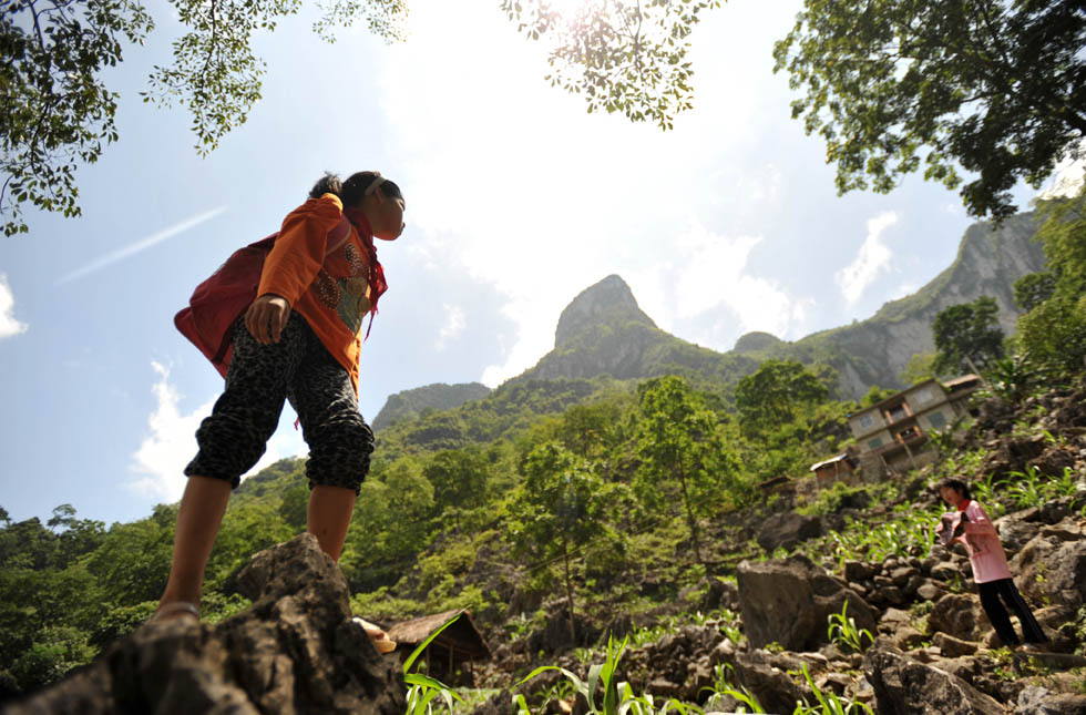 Two pupils are seen on a rugged way home in a village in Guangxi, May 31, 2013. Children living in the remote mountain area in southwest China’s Guangxi have to overcome rough mountain path and poor condition for education. (Xinhua/Lu Bo’an)