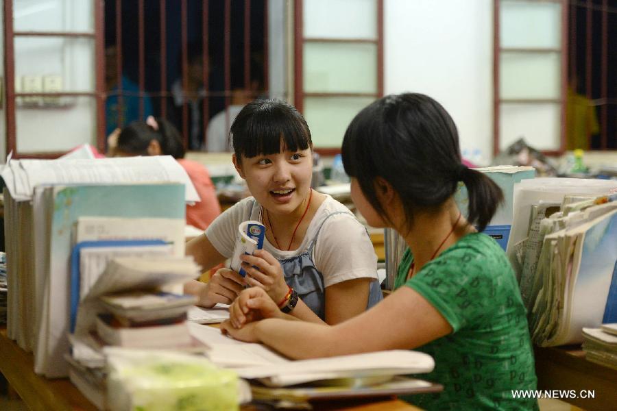 Students chat while preparing for the national college entrance exam at the Jinzhai No. 1 Senior High School in Liuan, east China's Anhui Province, June 5, 2013. The annual national college entrance exam will take place on June 7 and 8. Some 9.12 million applicants are expected to sit this year's college entrance exam, down from 9.15 million in 2012, according to the Ministry of Education (MOE). (Xinhua/Zhang Duan)