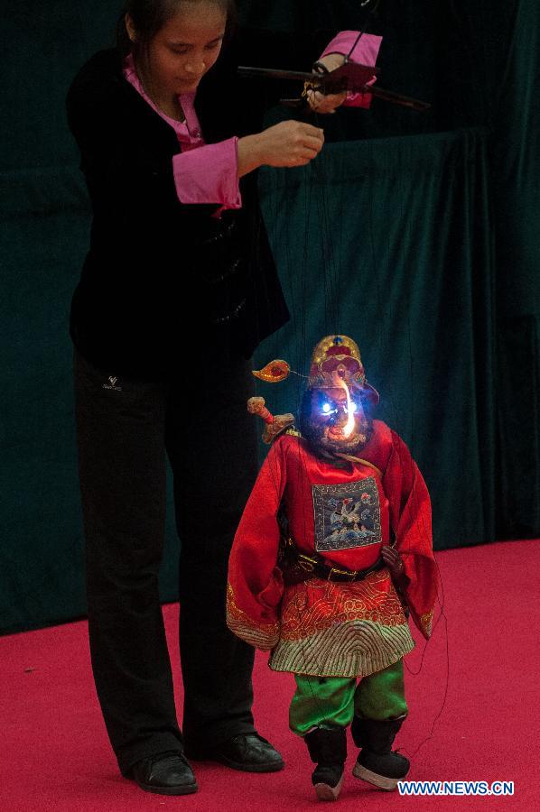 A performer operates a puppet during a Lingnan puppet show held by the Guangdong Provincial Puppet Art Theater at the Guangzhou Library to mark the 8th national Cultural Heritage Day in Guangzhou, capital of south China's Guangdong Province, June 8, 2013. (Xinhua/Mao Siqian)