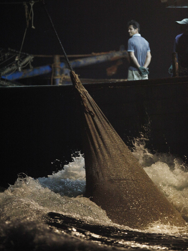 A fishing boat poaches shellfish in the darkness in Beibu Gulf in South China Sea on June 4, 2013. It was summer fishing ban period. Due to the over-exploitation and pollutant emissions, the ecosystem of the Beibu Gulf has been seriously damaged and the fishery resources have almost been exhausted.(Xinhua/Wang Shen)