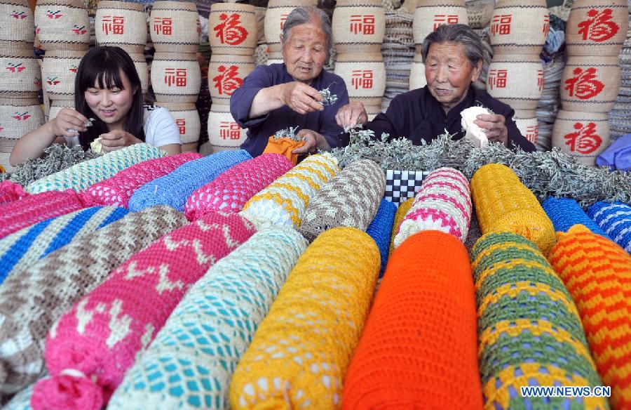 Villagers make pillows filled with Chinese mugwort leaf to celebrate the upcoming Dragon Boat Festival in Xiyuezhuang Village of Qiyuan County, east China's Shandong Province, June 9, 2013. (Xinhua/Zhao Dongshan) 