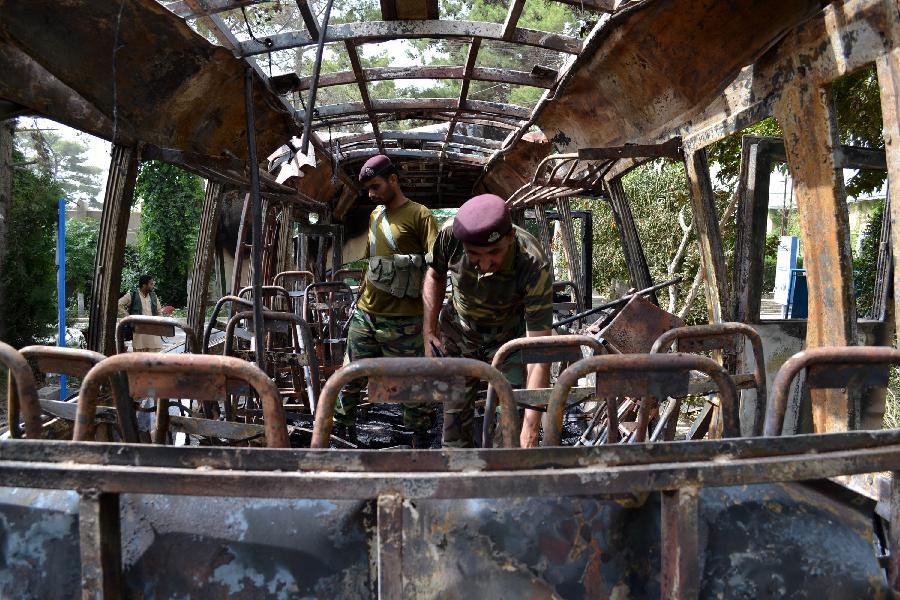 Pakistani security personnel inspect the burnt student bus a day after it was destroyed by a bomb blast in southwest Pakistan's Quetta, June 16, 2013. A day of mourning was observed across Pakistan's southwestern Balochistan province on Sunday over Saturday's bombings targeting the Women University bus and the Bolan Medical Complex which has claimed 20 precious lives. (Xinhua/Asad)