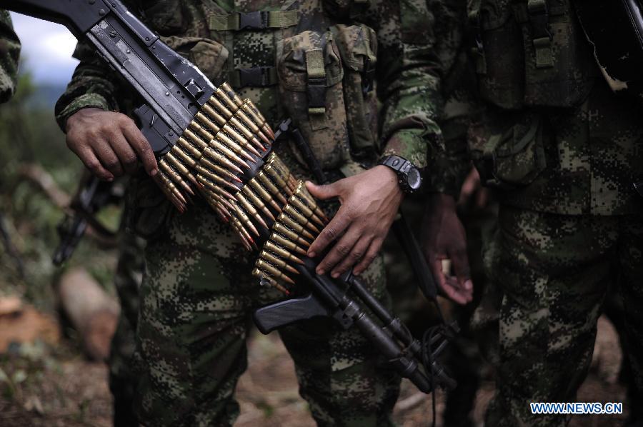 A soldier attends a raid at an illegal coca plantation, in Darien, Panama, on June 18, 2013. Panama National Border Police in conjunction with the Colombian army, found two hectares of illegal coca plantation next to a clandestine cocaine laboratory. Both authorities met on Tuesday to announce a new base in central Darien. The base will enforce security, combat the war on drugs and fight the guerrilla movement on the Panama-Colombia border, according to local press. (Xinhua/Mauricio Valenzuela)