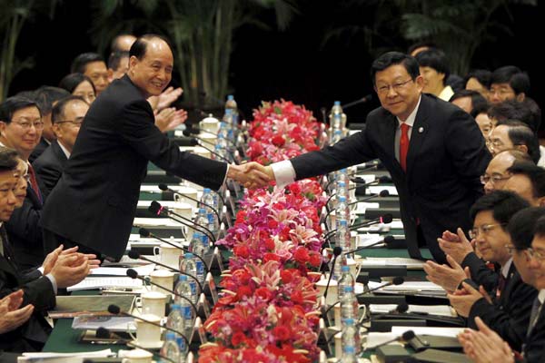 Chen Deming (right), president of the mainland-based Association for Relations Across the Taiwan Straits, meets his Taiwan counterpart Lin Join-sane, chairman of the Straits Exchange Foundation, during a meeting on Friday in Shanghai. Companies from the mainland and Taiwan will have greater access to each other's service sectors after the signing of a new draft trade agreement. PHOTO BY REN LONG / XINHUA