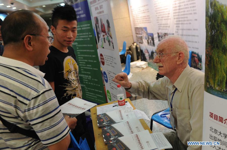 Students and parents inquire information at a college enrollment consultation fair in Shijiazhuang, capital of north China's Hebei Province, June 23, 2013. The fair attracted representatives of nearly 300 colleges. Approximately 9.12 million people all over China took part in the National College Entrance Examination early June. (Xinhua/Wang Xiao)