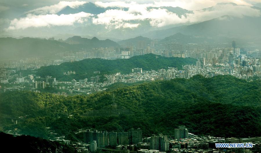 Photo taken on June 24, 2013 shows the western area of Taipei bathed in sunshine while the eastern area hit by rain in Taipei, southeast China's Taiwan. (Xinhua/Tao Ming)