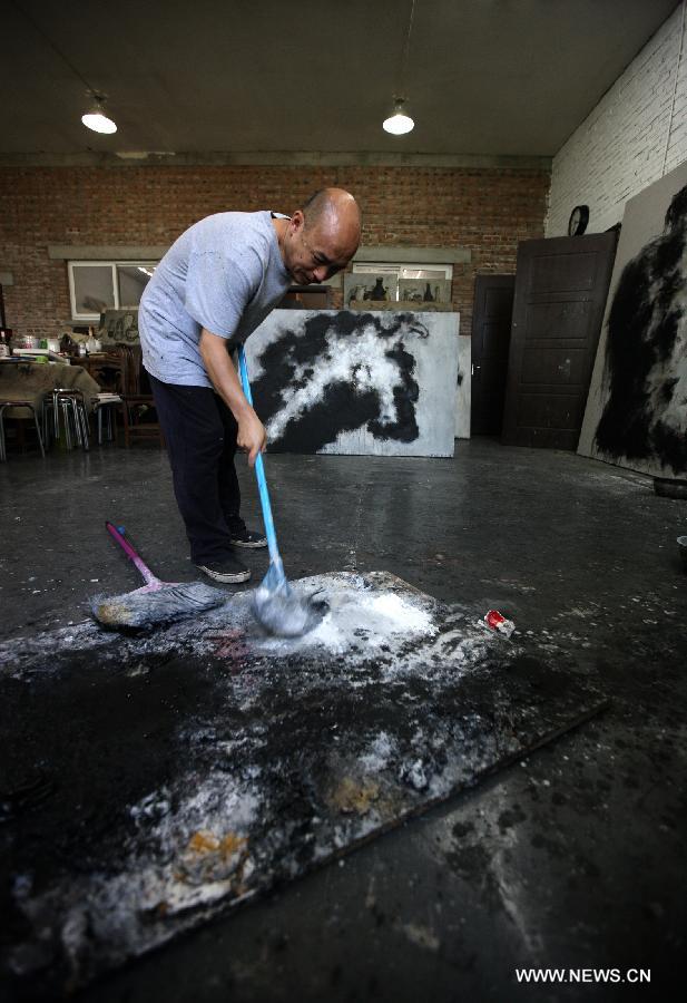 Zhang Fangbai, a 51-year-old painter, draws a picture at his studio in Beijing, capital of China, June 19, 2013. Zhang has specialized in painting eagles for a dozen of years. (Xinhua/Wu Xiaochu) 