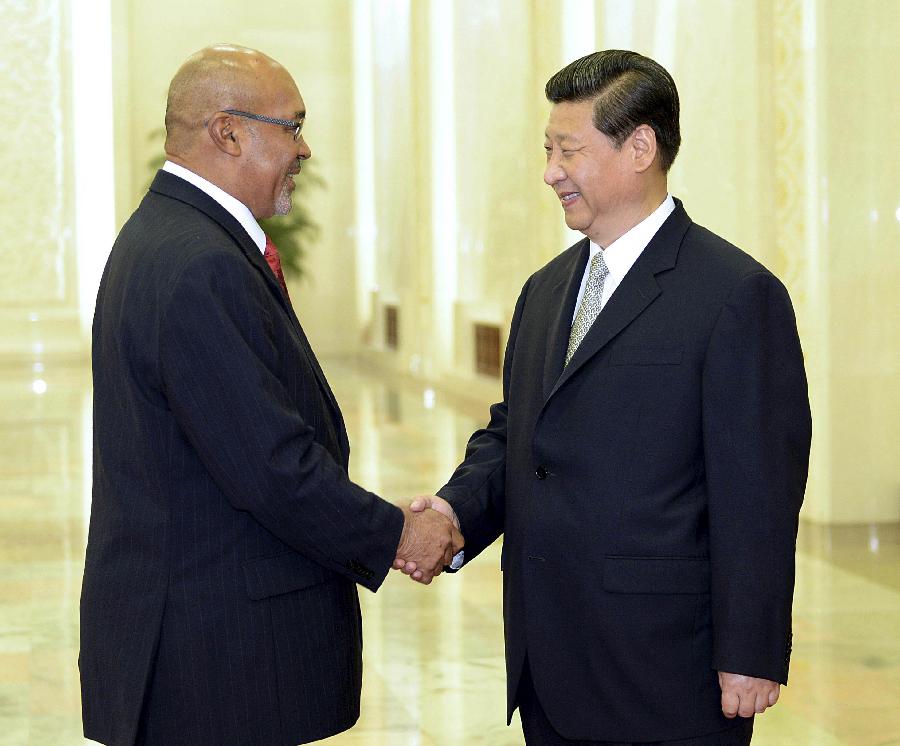 Chinese President Xi Jinping (R) shakes hands with Surinamese President Desi Bouterse who will attend the second annual World Peace Forum in Beijing, capital of China, June 26, 2013. (Xinhua/Li Tao) 