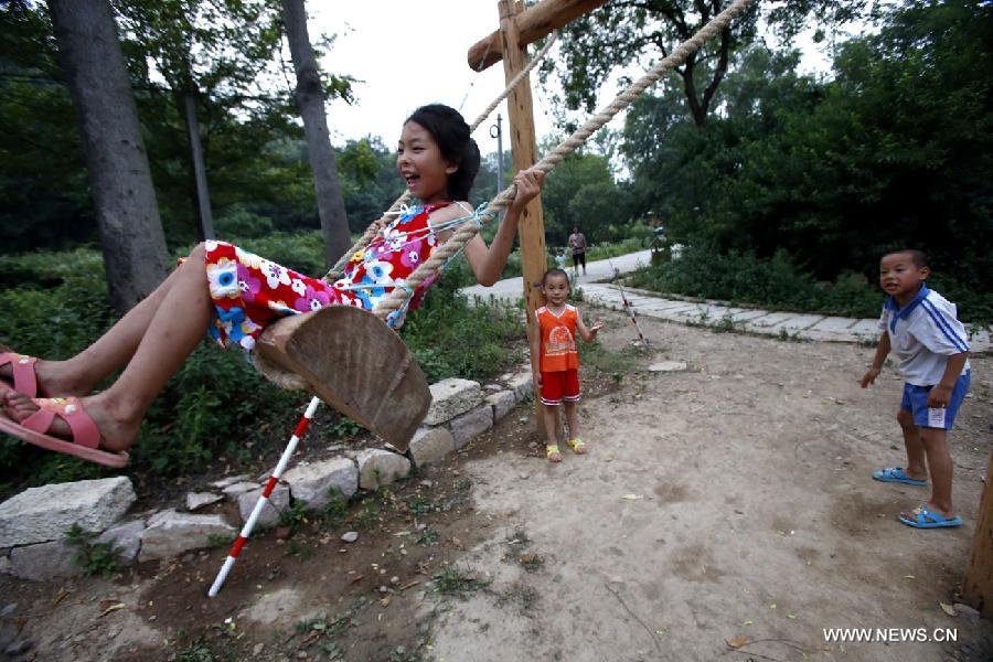 Children play on a swing in the Haotang Village of Xinyang City, central China's Henan Province, June 20, 2013. (Xinhua/Li Mingfang) 