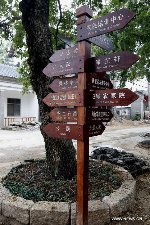 Photo taken on June 20, 2013 shows road signs in the Haotang Village of Xinyang City, central China's Henan Province. (Xinhua/Li Mingfang)