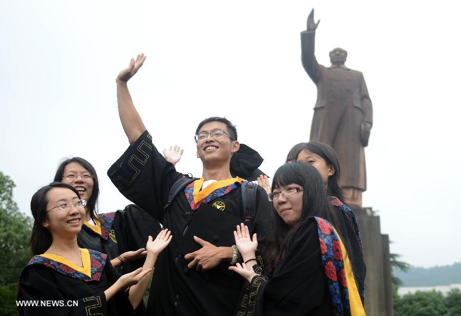 Graduates pose for photos during the graduation ceremony of Zhejiang University in Hangzhou, capital of east China's Zhejiang Province, June 29, 2013. The graduation ceremony was held here Saturday. (Xinhua/Han Chuanhao)