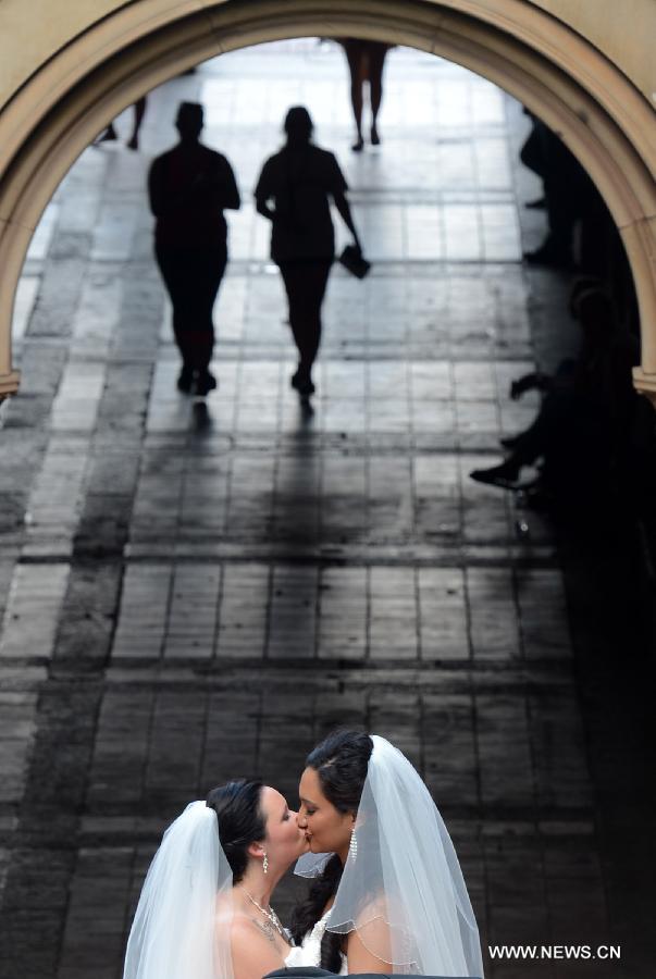 A homosexual couple kisses each other at the Central Park in New York City, June 28, 2013. U.S. Supreme Court on Wednesday issued a pair of rulings expanding homosexuals' right to marry, striking down Defense of the Marriage Act (DOMA), which bans same-sex married couples from receiving federal benefits, while declining to rule on another case concerning California's ban on same-sex marriage, opening the door for the state to legalize gay marriage. (Xinhua/Wang Lei) 