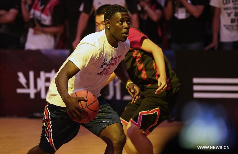 NBA star Jrue Holiday from Philadelphia 76ers (front) breaks through past a deputy of Chinese basketball fans during a business event in Beijing, capital of China, June 30, 2013. Four NBA stars Jrue Holiday from Philadelphia 76ers, Ricky Rubio from Minnesota Timberwolves, Damian Lillard from Portland Trail Blazers and John Wall from Washington Wizards shared their basketball skills and funs with Chinese fans during a business event in Beijing on Sunday. (Xinhua/Li Ming)