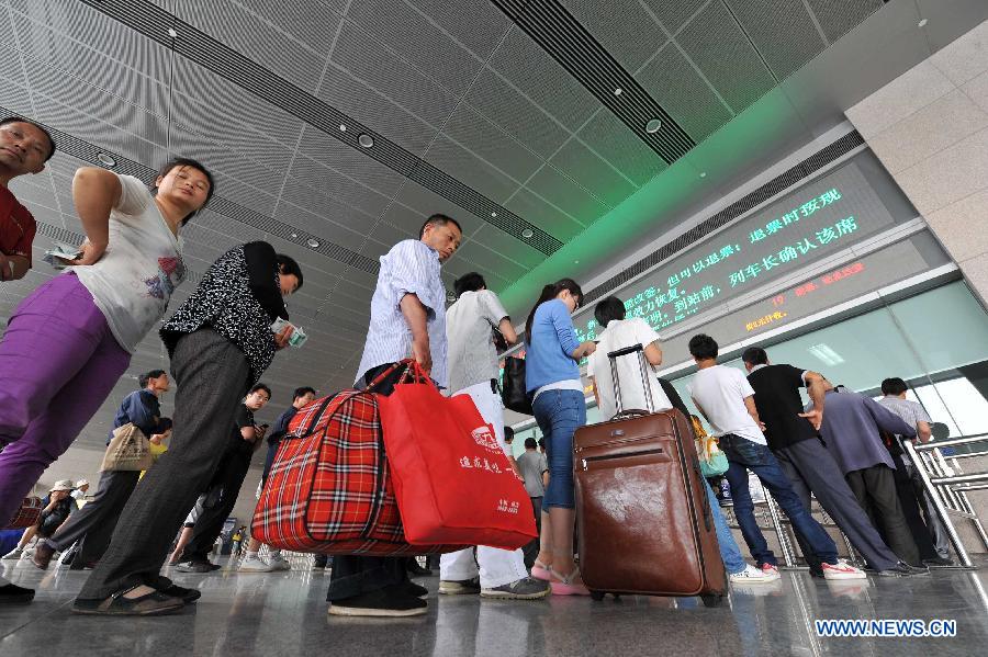 Passengers queue to buy tickets at the Yinchuan Railway Station in Yinchuan, capital of northwest China's Ningxia Hui Autonomous Region, July 1, 2013. China's summer railway travel rush started on Monday and will last until Aug. 31. (Xinhua/Peng Zhaozhi)