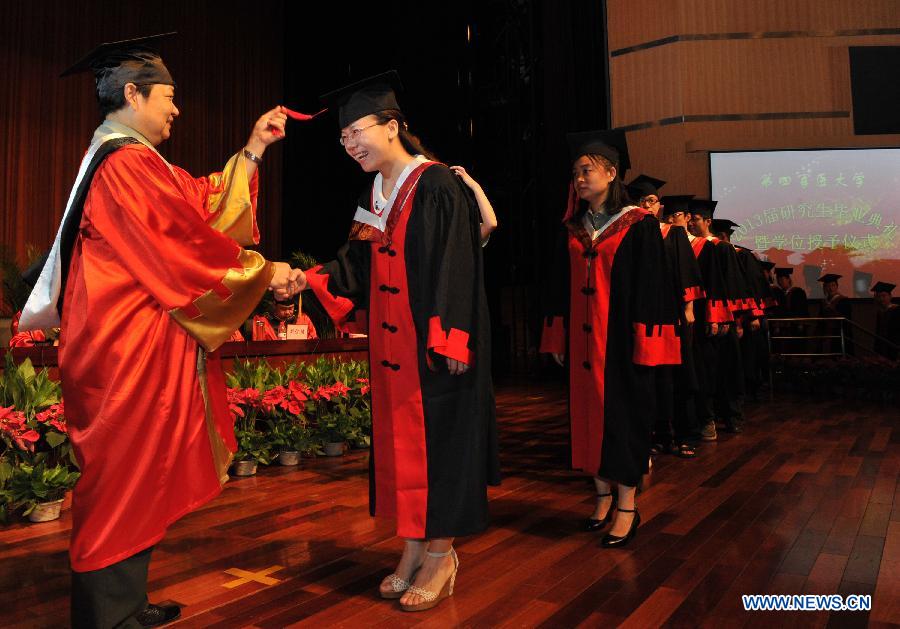 Zhao Yimin (1st L), acting president of the university, attends the graduation ceremony in the Fourth Military Medical University in Xi'an, northwest China's Shaanxi Province, July 5, 2013. Altogether 245 Ph.D. students and 575 postgraduate students graduated from the university this year. (Xinhua/Ding Haitao)