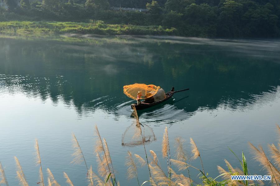 A fisherman fishes on the Xiaodongjiang River in Zixing City, central China's Hunan Province, July 7, 2013. (Xinhua/He Maofeng)