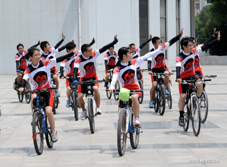 Cyclists wave to teachers and schoolmates before their expedition in Nanjing, capital of east China's Jiangsu Province, July 10, 2013. In celebration of the 60th anniversary of the founding of Nanjing University of Science and Technology(NUST), 15 students were selected to participate in a bike riding activity from Nanjing to Harbin where the old campus site was located. The roots of NUST can be traced back to 1952 when an institute of Military Engineering of the PLA was established. (Xinhua/Sun Can)