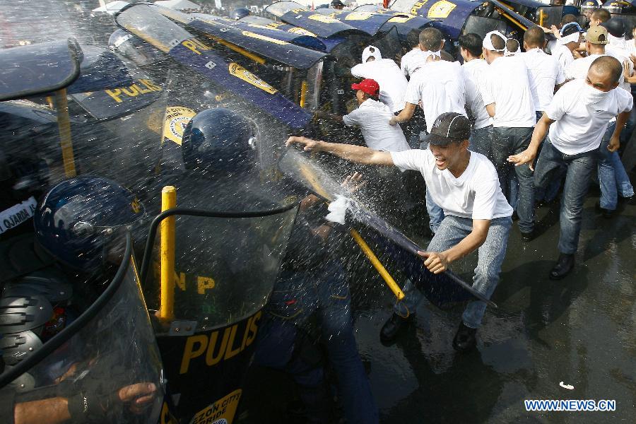 Mock protestors clash with members of the Civil Disturbance Management (CDM) of the Philippine National Police (PNP) during the CDM Competition in Manila, the Philippines, July 11, 2013. The competition aimed to assess the effectiveness and efficiency of the CDM Units on the police operational procedures in handling civil disturbance. (Xinhua/Rouelle Umali)