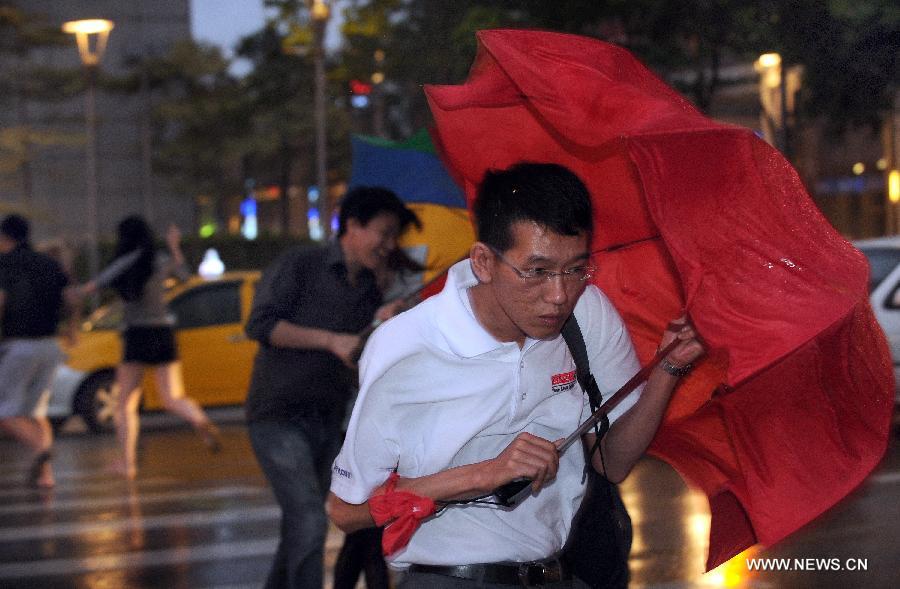 Citizens walk against rain and wind in Taipei, southeast China's Taiwan, July 12, 2013. Typhoon Soulik is expected to hit or pass waters near Taiwan late Friday or early Saturday morning before landing on the mainland on Saturday, according to the National Marine Environmental Forecasting Center. (Xinhua/Tao Ming) 