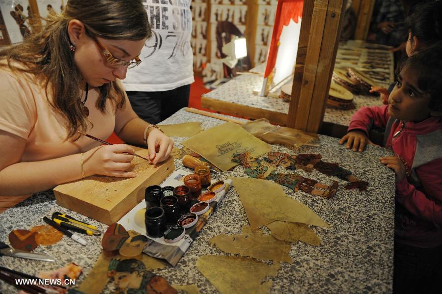 A Turkish shadow play craftswoman colours a shadow play character in Istanbul on July 18, 2013. The shadow play has been played in Turkey for some 700 years and it has long been a tranditional entertainment in Ramadan. (Xinhua/Lu Zhe) 