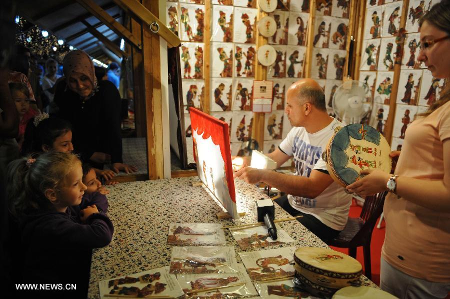 Children enjoy a shadow play in Istanbul on July 18, 2013. The shadow play has been played in Turkey for some 700 years and it has long been a tranditional entertainment in Ramadan. (Xinhua/Lu Zhe) 