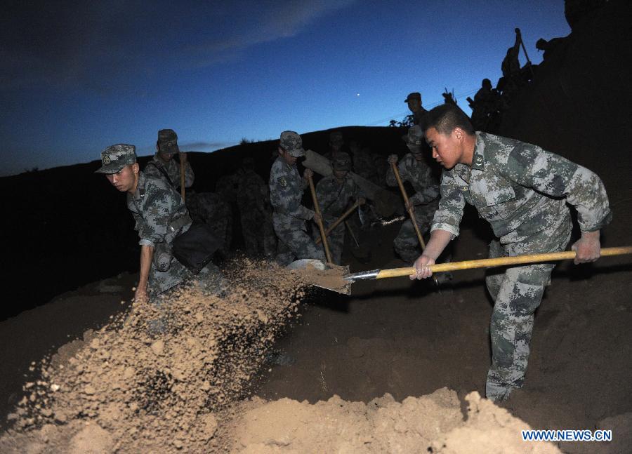 A rescue team of the Lanzhou Military Area Command excavates a mud-covered cellar for possible survivors at Yongguang Village in Meichuan Town of Minxian County, northwest China's Gansu Province, July 22, 2013. The death toll has climbed to 89 in an earthquake that hit the border of Minxian County and Zhangxian County in the city of Dingxi Monday morning, local authorities said. (Xinhua/Luo Xiaoguang)