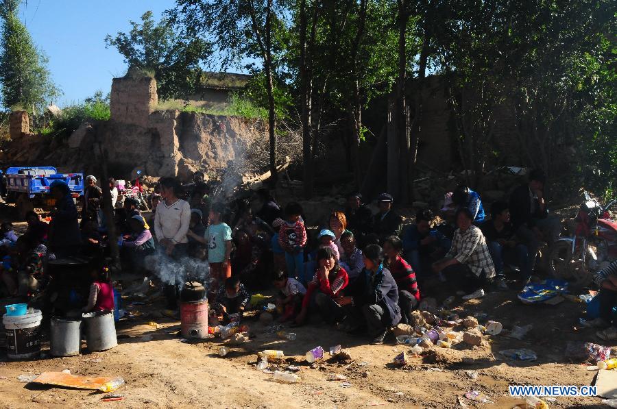 Displaced villagers boil drinking water after a 6.6-magnitude quake jolted Yongguang Village, Meichuan Town, Minxian County, northwest China's Gansu Province, July 22, 2013. At least nine villagers in Yongguang were killed in the quake and 12 others were burried in a landslide triggered by the quake. The rescue work is underway. (Xinhua/Tu Guoxi) 