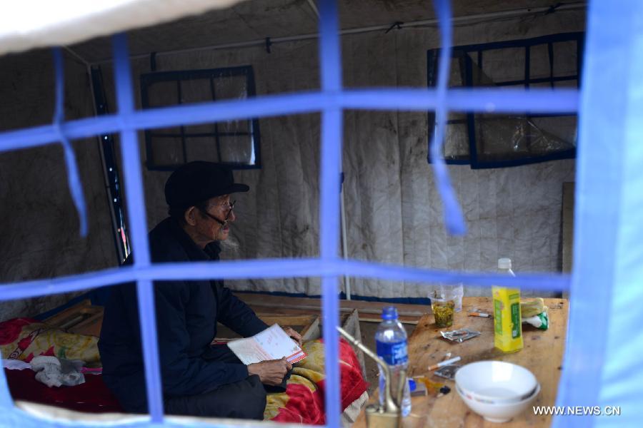 A villager sits in a makeshift tent in the quake-hit Majiagou Village, Meichuan Township, Minxian County, northwest China's Gansu Province, July 24, 2013. Due to a lack of tents, almost ten people could share one in the township. The Ministry of Civil Affairs dispatched more tents and quilts to the quake zone of Gansu on Tuesday evening. A 6.6-magnitude quake jolted the juncture of Minxian and Zhangxian counties in the city of Dingxi at 7:45 a.m. Monday, leaving at least 95 people dead as of Tuesday evening. (Xinhua/Jin Liangkuai)