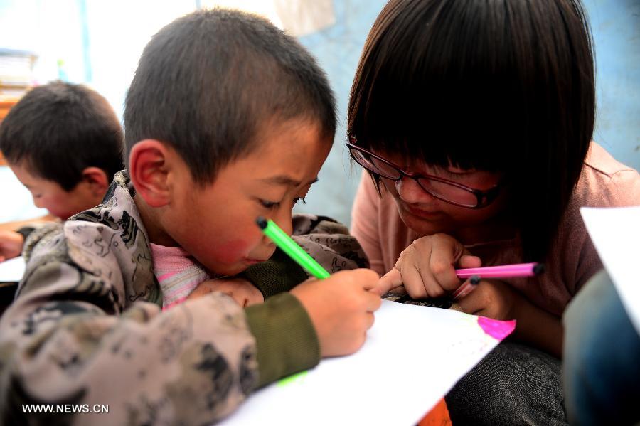 A volunteer teaches children in a "Tent School" in quake-stricken Yongxing Village of Minxian County, northwest China's Gansu Province, July 24, 2013. 10 university student volunteers teach various courses for those in need in the "Tent School" in quake-stricken Yongxing Village on Wednesday. (Xinhua/Zhang Meng)