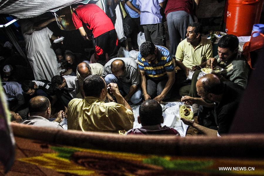 Supporters of Egypt's ousted President Mohamed Morsi have Iftar during a protest in Rabaa Al-Adaweya Square for the 29th day in row, Cairo, July 26, 2013. A top Egyptian court has ordered the detention of ousted Islamist-oriented President Mohamed Morsi for 15 days for investigations over charges of spying and jailbreak, official media reported Friday. (Xinhua/Amru Salahuddien) 