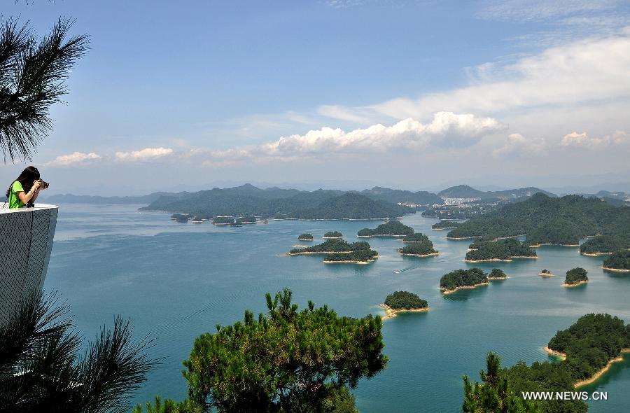 A tourist take photos of the Qiandao Lake (Thousand Island Lake) from an elevated platform in Chun'an County, east China's Zhejiang Province, July 27, 2013. (Xinhua/Hao Qunying)