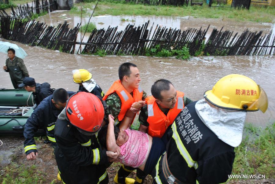 Rescuers transfer trapped residents in flood-hit Genhe City, Hulun Buir, north China's Inner Mongolia Autonomous Region, July 28, 2013. Rainstorm-triggered flood hit the city on Sunday. (Xinhua/Feng Changcai)