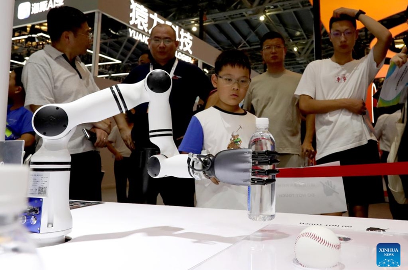 Visitors watch a bionic hand showcasing grab skill during the 2024 World AI Conference in Shanghai, east China, July 5, 2024. AI-powered products and applications have captivated lots of visitors during the 2024 World AI Conference. Photo: Xinhua